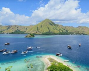 pemandangan Labuan Bajo dengan kapal pinisi dan bukit hijau